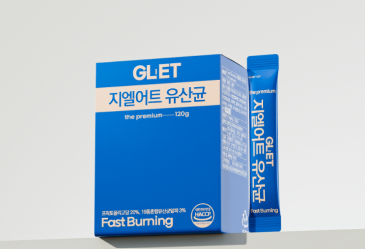 지엘어트 유산균 제품 박스와 스틱형 개별 포장 제품이 함께 놓여 있는 모습. 파란색 패키지에 'the premium 120g' 문구가 인쇄되어 있으며, Fast Burning 기능과 HACCP 인증 마크도 확인 가능함.